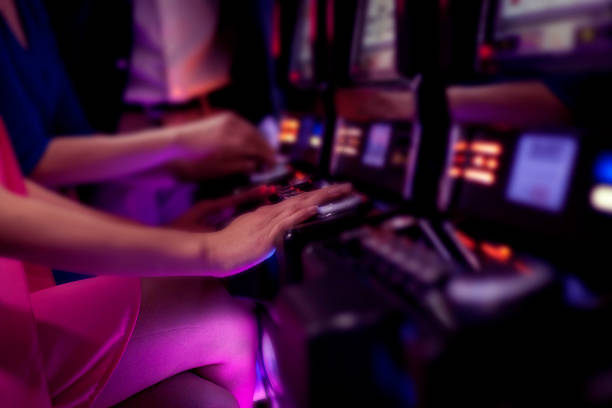 Young adult women gambling on a slot machine in a casino.