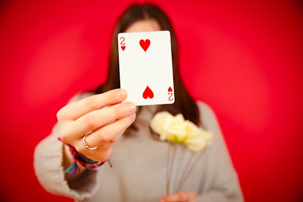 free-photo-of-woman-holding-a-two-of-hearts-card